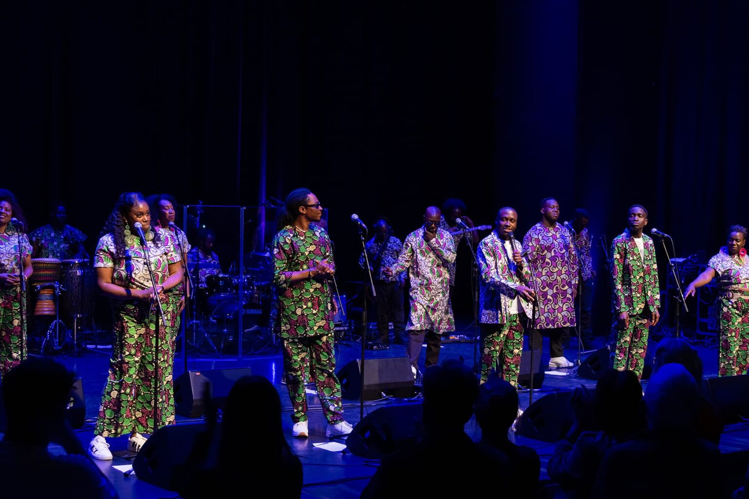 London African Gospel Choir performing on stage in zebra-print shirts and colourful print dresses