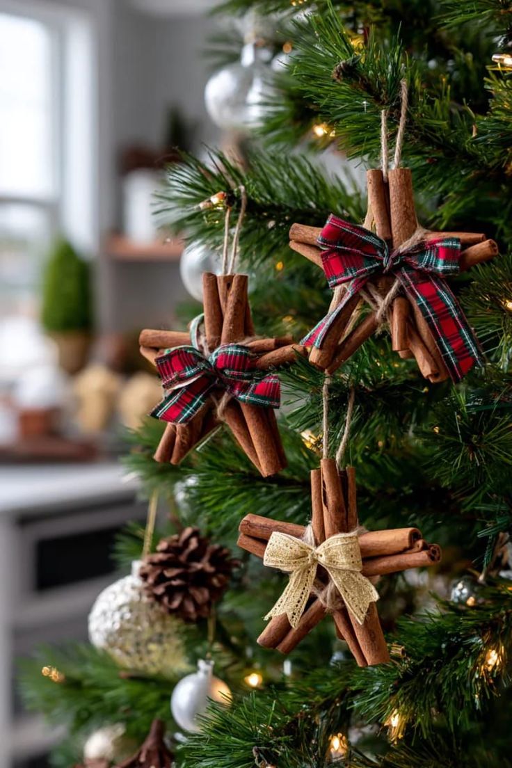 Handmade cinnamon-stick star ornaments tied with tartan and lace bows on a Christmas tree