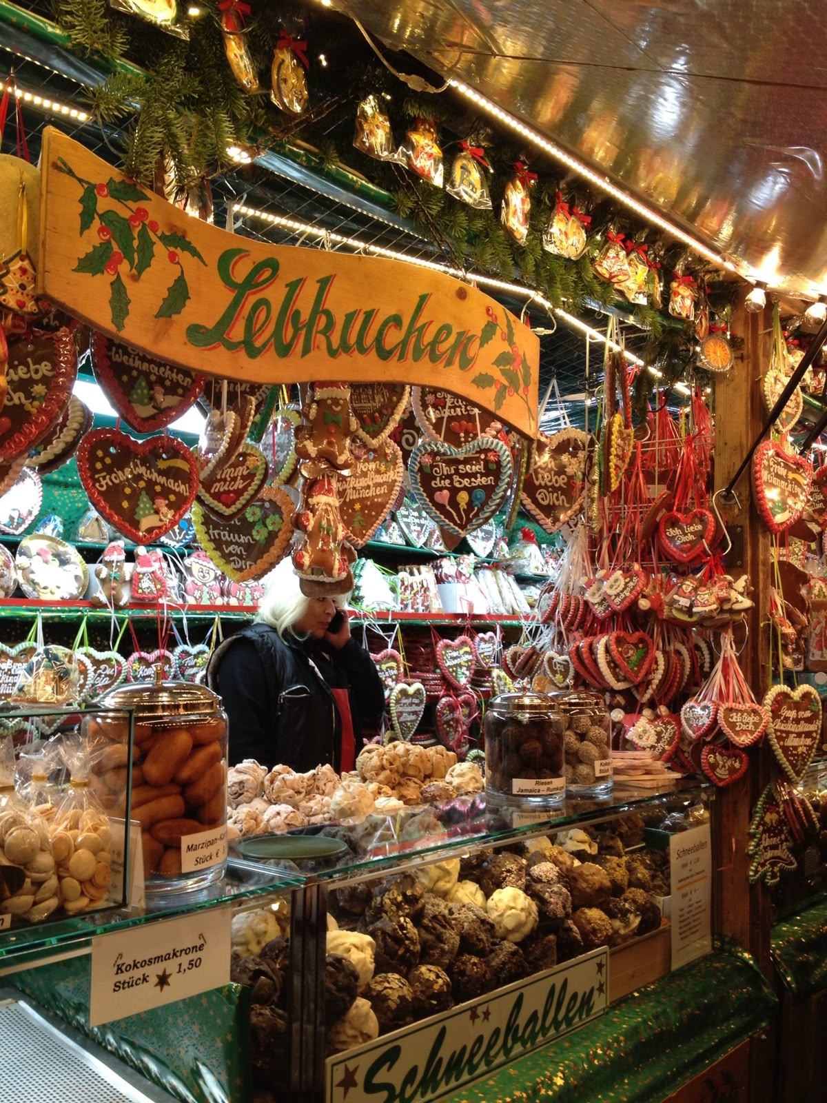 A traditional Lebkuchen stall hung with decorated gingerbread hearts and warm string lights